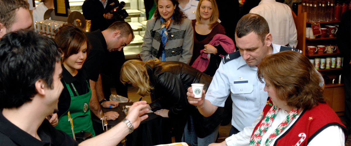 starbucks opening in US Air Force base, filled with happy customers eating and drinking