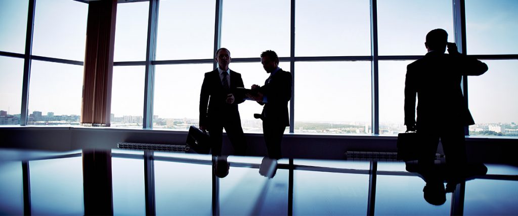 boardroom etiquette with three executives, silhoutted, penthouse view