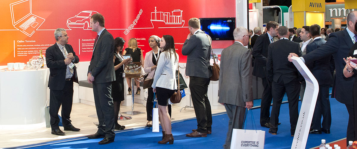 conference attendees in front of a booth, networking and building relationships