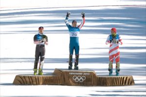 olympic medal ceremony, vancouver 2010, gold medalist holding arms up in triumph
