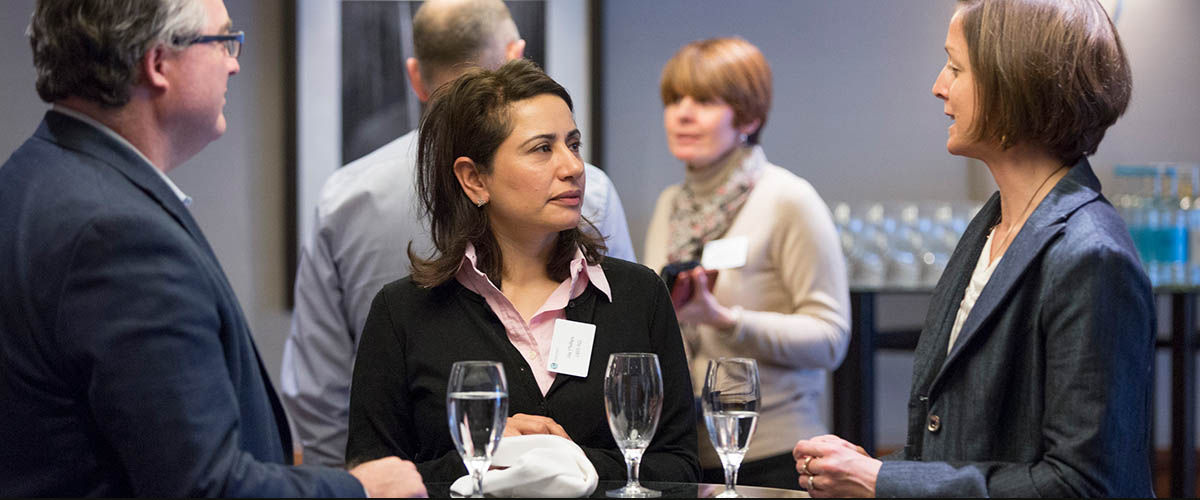 group of executives networking, eating dinner, and exchanging business cards