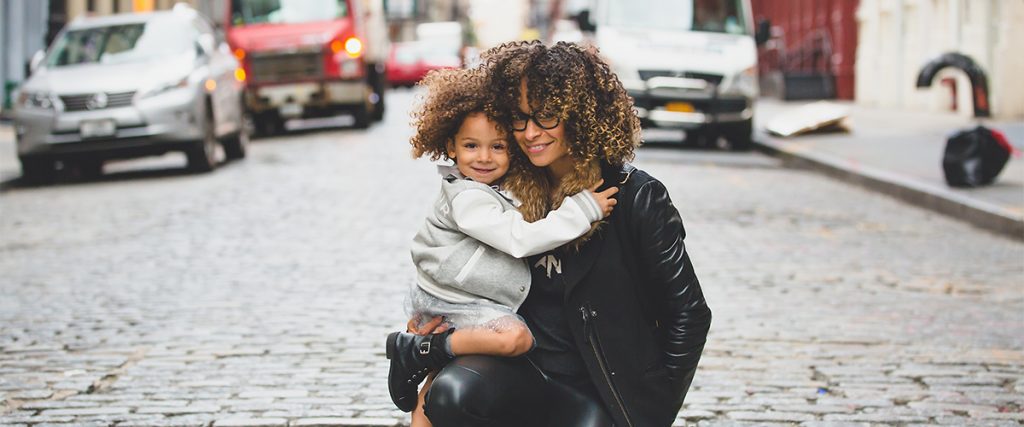 happy mother's day photo with a mom and her daughter smiling while hugging