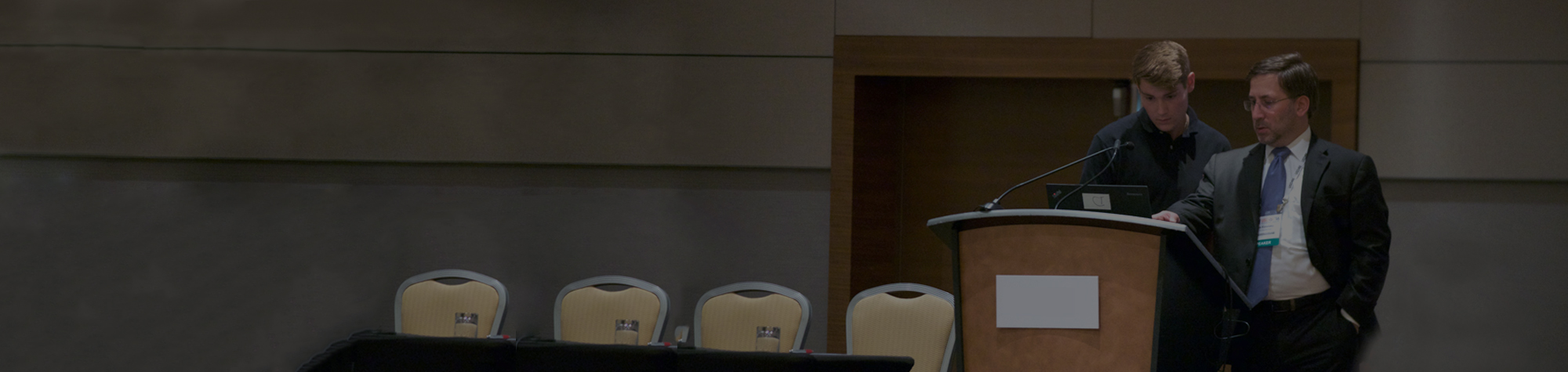 header photograph for speaker coach with ira koretsky and youg executive on stage preparing for an upcoming speech