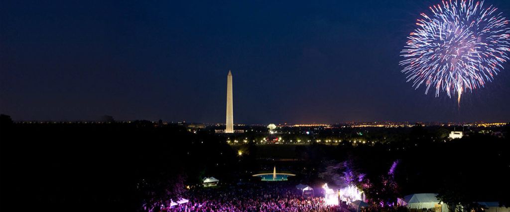 happy july 4th looking down at the us capitol grounds at night with fireworks display in the perfect blue night sky