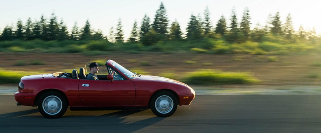 red convertible driving on the highway