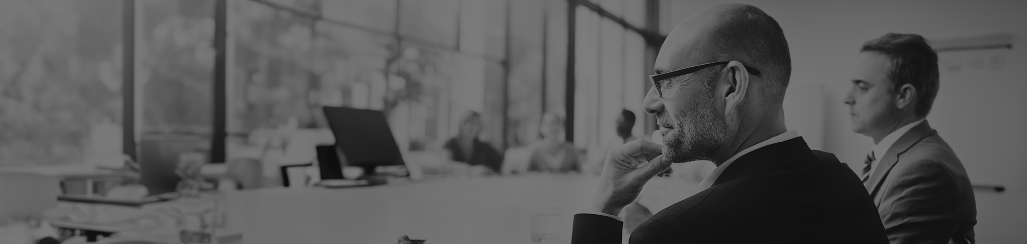 executive deep in thought, hand on chin, thinking about his M&A coach engagement